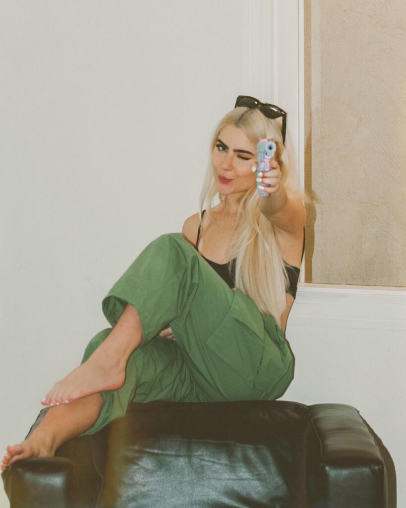 Foto da Jade Picon do BBB 22, de calça verde, top preto e cabelo loiro